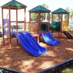 Red and blue playground with turf and fence