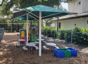 picnic tables under green umbrella | creativerecproducts.com