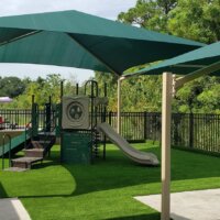 green and tan playground equipment and shade | creativerecproducts.com